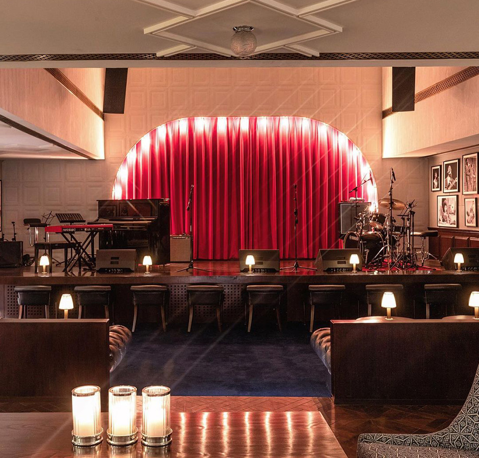 A front view of restaurant having musical instruments such as drums, piano, guitar and many more