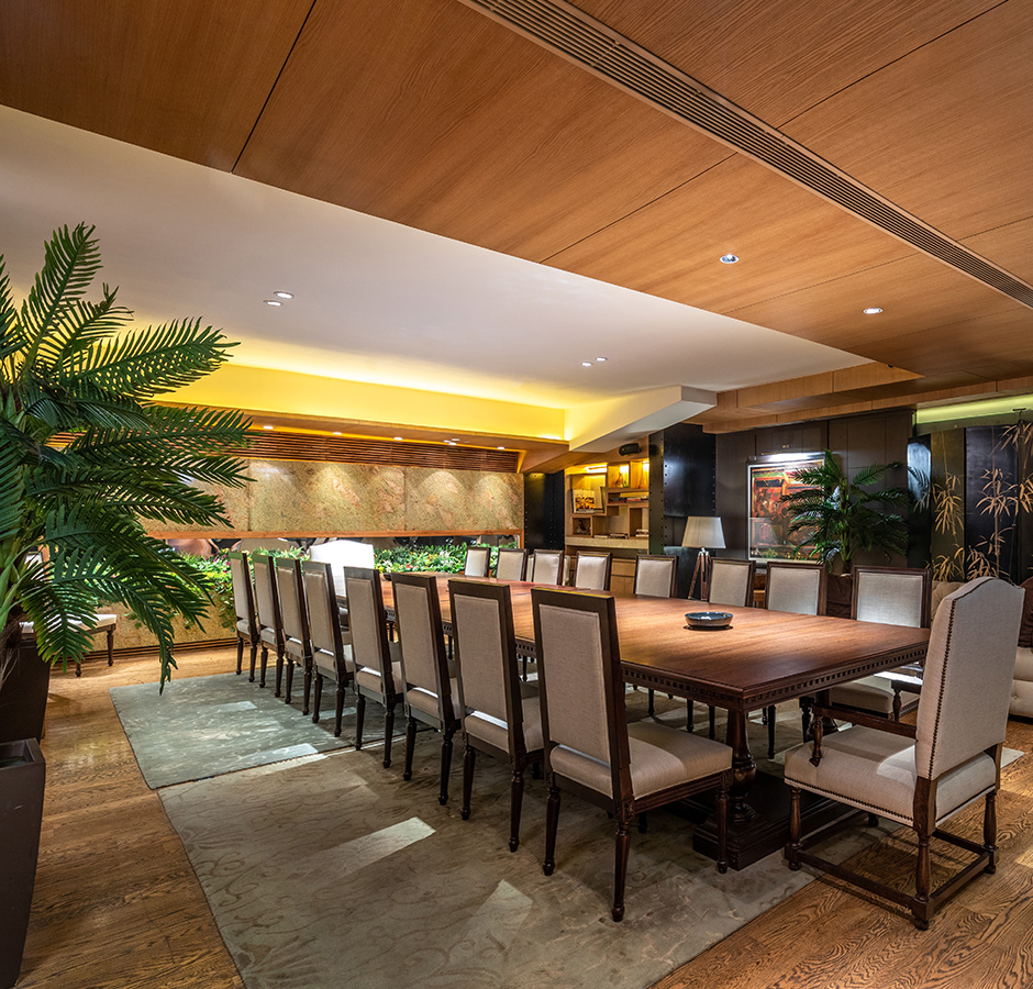 A side view of the dining hall has tables, chairs along with green plants